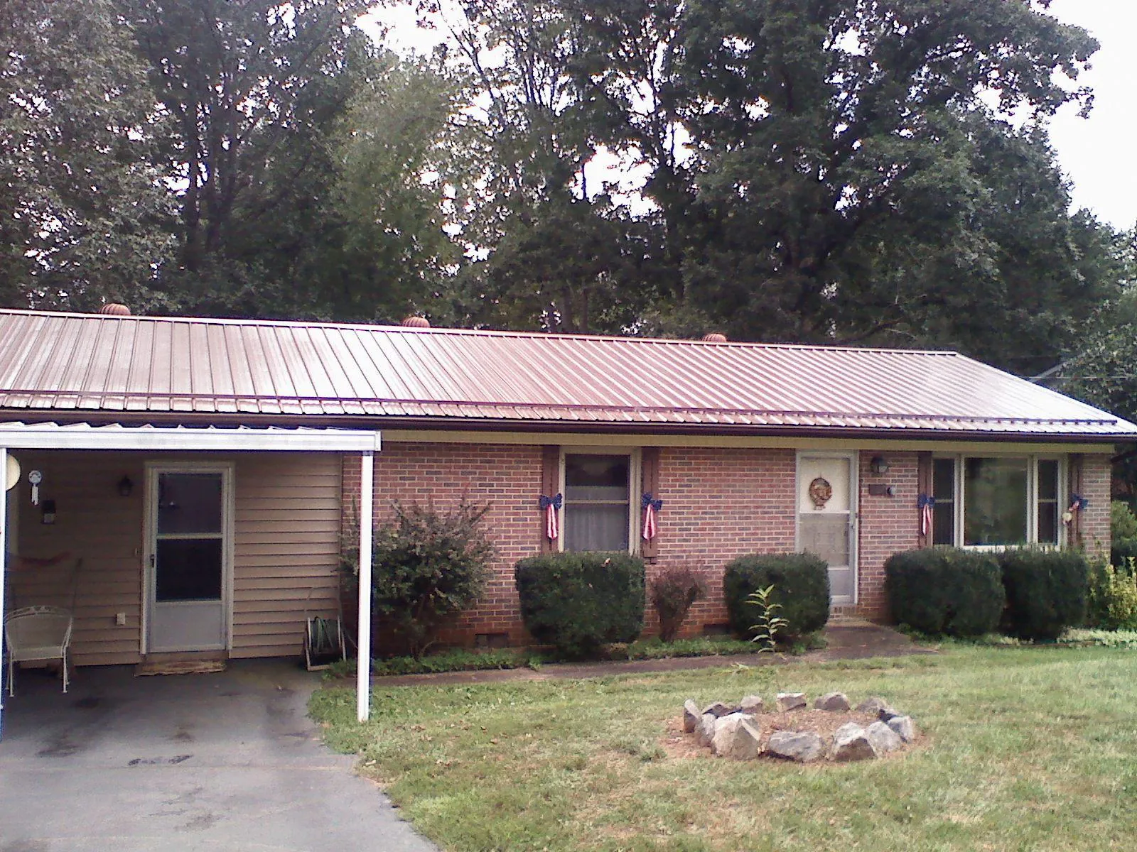 Bronze metal roof and carport on a brick ranch home — Roof Repair work by our crew in Mableton