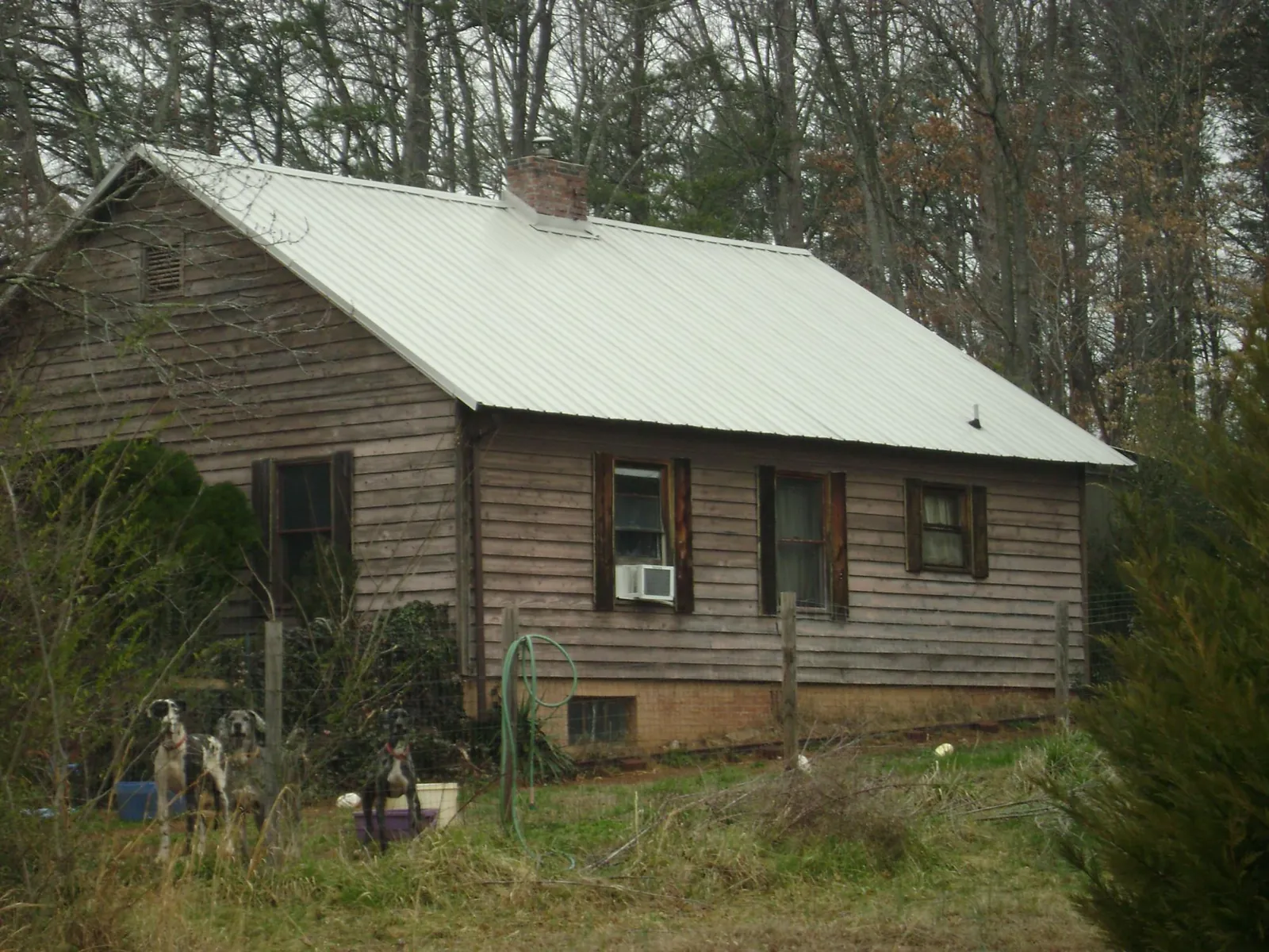 White metal roof on an old wood sided farmhouse, from a Metal Roof Installation job in Mableton